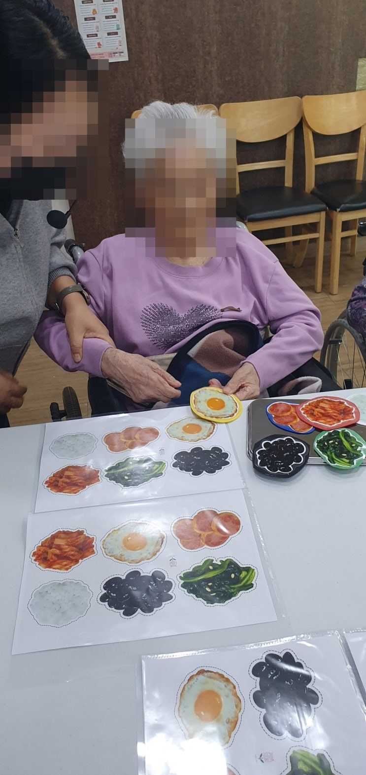 보조자 선생님과 함께 워크지에 반찬을 올리시는 어르신