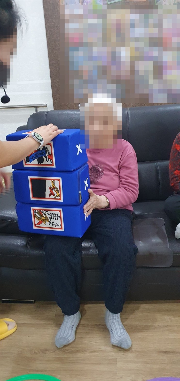 쌓아 올린 화투 주사위를 잡고 계신 어르신