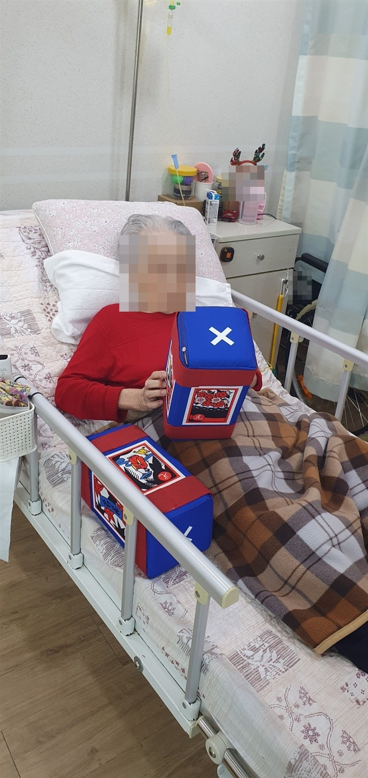 침상에서 화투 주사위를 들고 계신 어르신