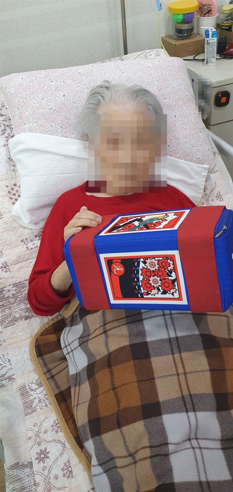 침대에 기대어 주사위 그림을 바라보시는 어르신