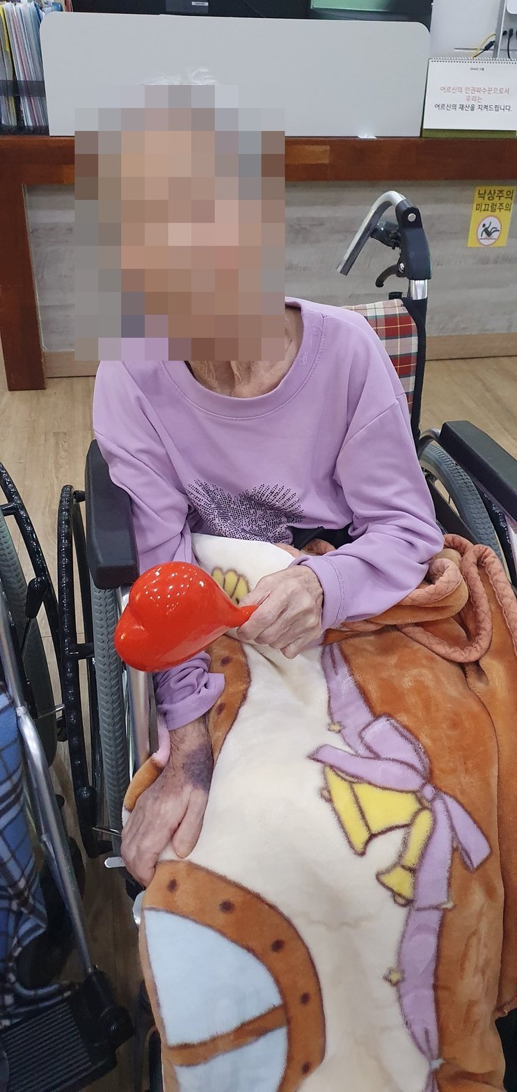 담요를 덮고 마라카스로 활동에 참여하시는 어르신