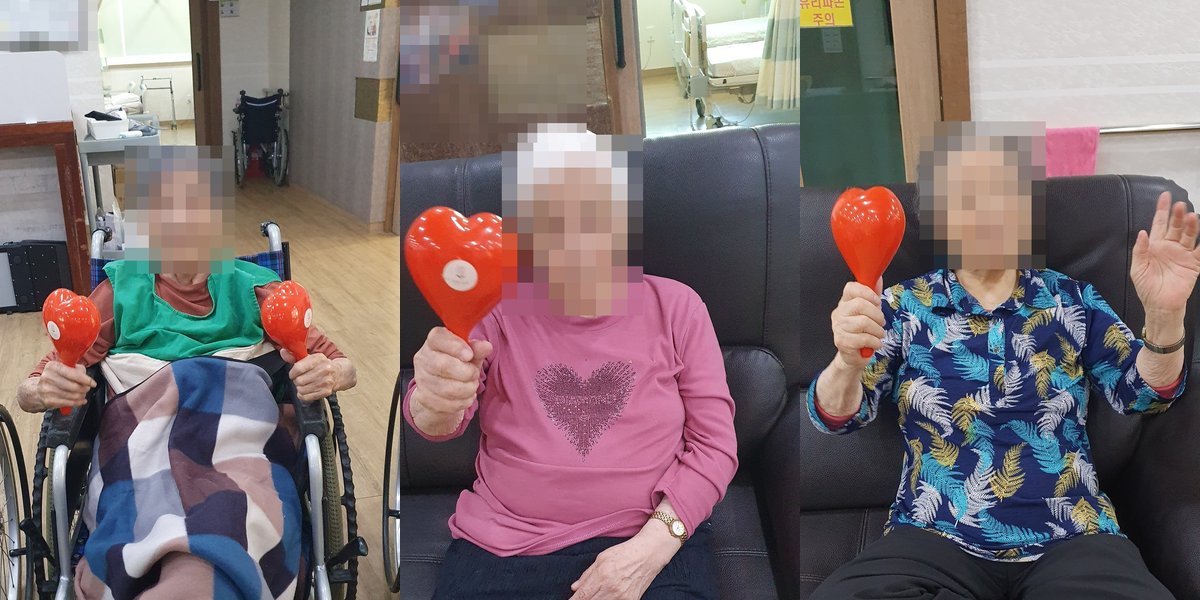 청주 성지요양원 어르신들이 빨간 하트 마라카스를 들고 악기 연주에 참여하는 모습, 얼굴은 개인정보 보호를 위해 모자이크 처리