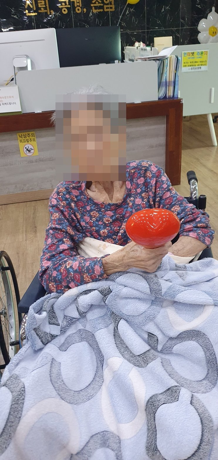 무릎 담요를 덮고 마라카스를 쥐고 계신 어르신