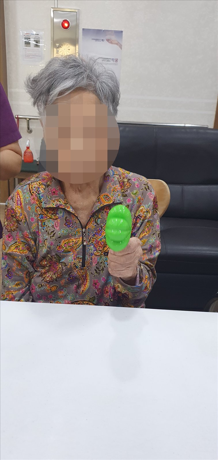 초록색 네잎클로버 마라카스를 들어 보이시는 어르신