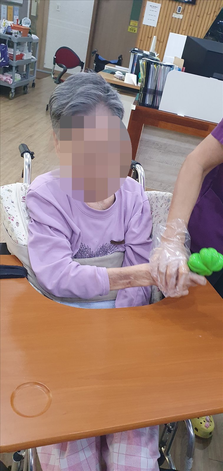 선생님이 손을 함께 잡고 마라카스를 흔들어 드리는 모습