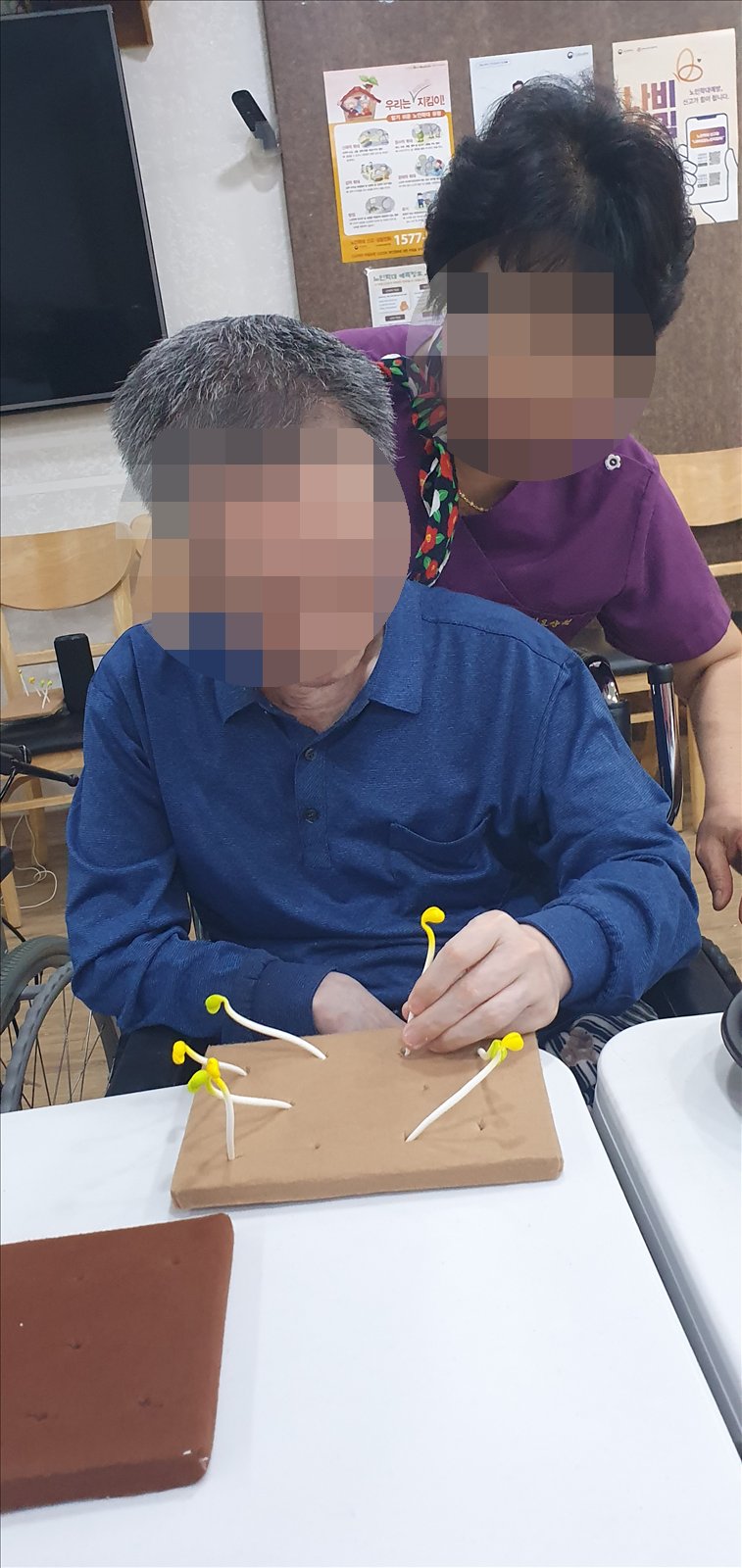 선생님과 함께 콩나물 모형을 꽂으시는 어르신